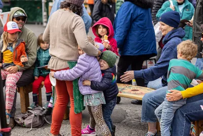 Children hug Aimee Dailey-Fallat, owner of Planted: Plant-based Fare, a locally sourced plant-based catering company, while she sets up for a food demonstration at the Port Townsend Farmers Market in Port Townsend, Washington on July 17, 2023.